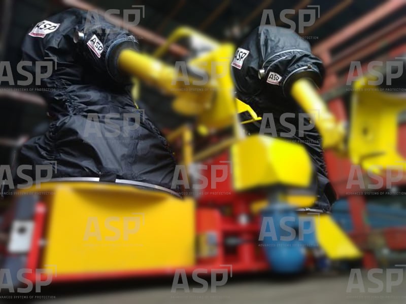 two yellow industrial robots, one next to the other, protected by two black robot covers for ATEX environments with explosive atmospheres